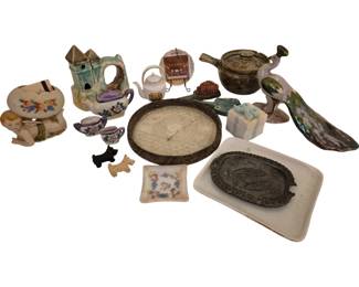 4004 - Group Lot of Ceramic & Glass Items (Description): A varied group lot of decorative items  including ceramic figurines, teapots, cups, a  castle-form planter, a cherub planter with  floral decoration, miniature Scottie dog  figurines, a lace-edged oval tray, an iridescent peacock figurine, a pewter or  metal decorative dish with bird motif on  white tray, a small gift box form container,  and various other ceramic and glass  decorative pieces.