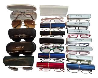 2707 - Group of Reading Glasses & Sunglasses (Description): A collection of reading glasses and  sunglasses featuring various brands including  Guess, Tura, After Six, and Scojo. The group  includes multiple pairs of compact folding  reading glasses with coordinating cylindrical cases, as well as full-size eyeglasses and  sunglasses with hard shell cases. Frames  feature assorted styles and colors including  tortoiseshell, gold, pink, green, and neutral  tones.