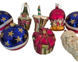 4059 - Group of Glass Christmas Ornaments (Description): Group of glass Christmas ornaments featuring  a variety of decorative styles. The  collection includes large blue balls adorned  with gold stars and red and white striped  accents, a pink present-shaped ornament with bow detail, figural ornaments including a  Santa head with silvery beard, a champagne  bottle in bucket, a bell, and a pink ball  marked "Merry Christmas" with Santa figure.  Assorted sizes and designs suitable for