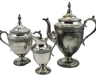 702 - Rogers Bros Silver Plated 3 pc Tea Set (Description): A set of three Triple Plate Rogers Bros  silver plate items. The set includes a coffee  pot, sugar bowl with lid, and creamer, all  featuring classical urn-form shapes with  Greek key decorative banding and beaded trim details.