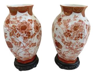 424 - Pr Japanese Kutani Porcelain Vases w/ Stands (Description): A pair of Japanese Kutani porcelain vases  presented on carved wooden stands. The vases  feature traditional Kutani decoration in rust  red and gold tones with floral motifs.  Measures 13" x 7".