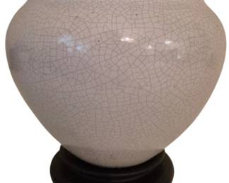3927 - Crackle Glaze Ceramic Pot on Wood Stand (Description): A white ceramic pot featuring an attractive  crackle glaze finish, resting on a carved  wooden display stand. The pot has a rounded  body with a flared rim, showcasing the  characteristic crackle pattern throughout the glaze. Measures 11" x 12".