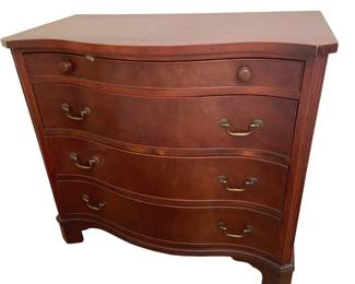 1334 - Serpentine Front 4 Drawer Mahogany Chest (Description): A four-drawer wooden chest featuring a  serpentine front design with brass bail pulls  on the lower three drawers and round wooden  knobs on the top drawer. The chest stands on  bracket feet and measures 35 inches tall by 32.5 inches wide by 18 inches deep.