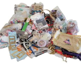 454 - Large Lot of Sewing & Craft Supplies (Description): Extensive lot of sewing and craft supplies  including needlepoint canvas with partially  completed design, assorted fabric pieces,  leather strips, hole punches and crafting  tools, brass stencils, beads and findings, ribbons, embroidery hoops, elastic bands,  decorative trims, and various notions.  Collection includes both vintage and  contemporary supplies suitable for a variety  of needlework and crafting projects.