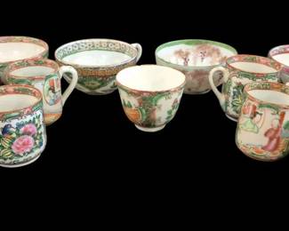 499 - Oriental Rose Medallion Cups 13 Pcs (Description): A collection of 13 Oriental Rose Medallion  porcelain pieces. The pieces feature  traditional hand-painted designs with figural  and floral panels in characteristic pink,  green, and gold coloring typical of Rose Medallion ware. The collection includes  various sizes of teacups and small bowls with  delicate handles.