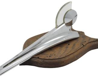 1883 - Vintage Ford Mohawk Hood Ornament 6"x12"x7" (Description): Vintage Ford Mohawk hood ornament mounted on  a wooden display base. This classic  automotive collectible measures 6 inches by  12 inches by 7 inches.