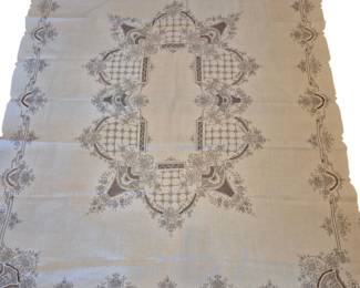 1460 - Embroidered Linen Tablecloth 67 x 84 (Description): Featuring an elegant cream-colored ground  with taupe and brown floral and geometric  embroidery. The design showcases a central  medallion motif with lattice work and floral  sprays, surrounded by an ornate border with corner fan designs and repeating decorative  elements. The piece displays fine needlework  typical of quality vintage linens.