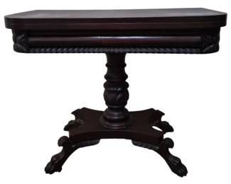 305 - Ant. Mahogany Fold-Top Game Table 28.5x36x18 (Description): Antique mahogany fold-top game table  featuring a hinged top that opens to 36  inches. The table displays classic  Empire-style design elements including a  turned pedestal column with acanthus leaf carving, rope twist edge detailing along the  apron, and