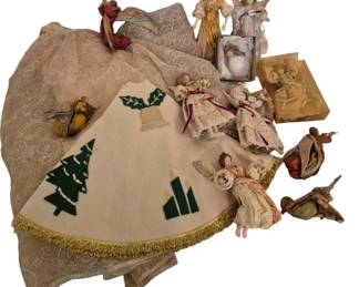 4067 - Group Lot Angels & Christmas Tree Skirts (Description): A charming collection of vintage Christmas  decorations featuring tree skirts and angel  figures. The lot includes multiple tree  skirts in cream and gold tones with lace and  brocade patterns, as well as a felt skirt decorated with applique Christmas trees,  candles, and holly with gold fringe trim. The  assortment of angel figures varies in size  and style, featuring figures with delicate  fabric gowns in muted tones of gold, cream,