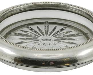 75 - Frank M. Whiting Sterling & Glass Bottle Coaster (Description): Frank M. Whiting sterling silver and glass  bottle coaster. The coaster features a  sterling silver rim with beaded detailing and  a cut glass insert with a starburst pattern.  Measures 1.5 inches high by 6.5 inches in diameter.