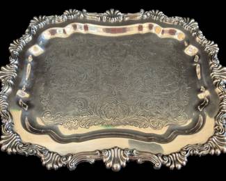 513 - Rogers Silver on Copper Engraved Tray (Description): FB Rogers Silver Co silver on copper serving  tray featuring an ornate shell and scroll  border with elegant rococo styling. The  center displays intricate hand-chased floral  and foliate engraving in a Victorian pattern. The tray has a shaped rectangular form with  scalloped edges and rests on decorative  scroll feet. Measures 14 inches by 11 inches.