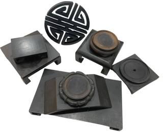 960 - Collection of Asian Style Dark Wood Bases (Description): A collection of dark wood display bases in  various Asian-inspired styles. The grouping  includes several square pedestal bases with  stepped profiles, a circular longevity symbol  trivet or stand with geometric openwork design, and bases featuring circular recessed  tops suitable for displaying vases, bowls,  or decorative objects. The bases exhibit  rich, dark finishes characteristic of  traditional Chinese display stands.