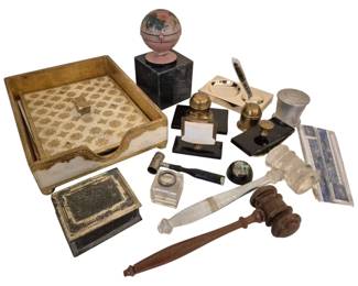 4016 - Group Lot of Assorted Desk Accessories (Description): A diverse collection of desk accessories  including a decorative globe on a black  marble base, a gilded paper tray with  patterned liner, various inkwells in glass  and brass, a wooden gavel, paperweights, a card holder, a small decorative box with  embossed lid, an aluminum top hat paperweight  or stamp moistener, and assorted small desk  items. The lot features a mix of materials  including glass, brass, wood, and marble,
