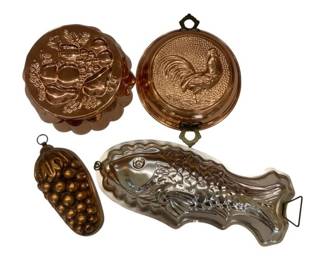 658 - Decorative Copper & Metal Molds (Description): A collection of decorative molds in copper  and metal finishes. The assortment includes  various shapes and designs suitable for  display or culinary use, each featuring  hanging loops or rings for wall mounting.