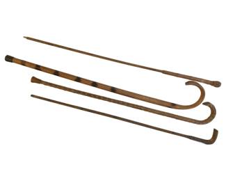 325 - 4 Wood Canes 26" (Description): Collection of four wooden canes in varying  styles. The canes include examples with  curved crook handles and straight designs,  some featuring natural wood grain patterns  and decorative carved details. Measures 26 inches.