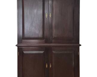 2045 - Traditional Dark Cherry Wood Armoire 72x45x24 (Description): Traditional armoire in dark cherry wood  finish featuring a two-piece construction.  The upper cabinet has two paneled doors with  brass drop handles, while the lower base  section also features two paneled doors with matching brass hardware. The piece rests on  bracket feet and displays classic  Georgian-inspired styling.