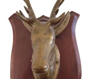 448 - Brass Deer Head Wall Plaque 14"x6.5" (Description): Decorative brass deer head mounted on a  shield-shaped wooden plaque. The stag  features detailed antlers and a classic  trophy-style presentation. The wooden backing  has a rich mahogany finish. Measures 14 inches by 6.5 inches.