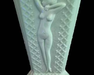409 - Nude Jadeite Glass Vase As Is 8.5" (Description): Jadeite glass vase featuring a nude female  figure in relief. The vase has a tapered form  with a lattice pattern and rests on a  decorative footed base. Measures 8.5 inches.  Sold as is with crack pictured. Glows under black light