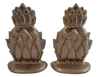 460 - Brass Pineapple Bookends 4"x6.5" (Description): Pair of solid brass pineapple bookends  featuring a classic tropical motif. Each  bookend displays a sculptural pineapple  design mounted on a half-moon shaped base.  The brass exhibits a warm patina consistent with age.