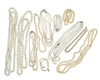 1985 - Collection of 9 Faux Pearl Necklaces (Description): A collection of faux pearl jewelry comprising  nine necklaces and two bracelets. The  assortment features varying pearl sizes and  styles, including single strand,  multi-strand, and graduated designs. The pieces showcase cream and white toned faux  pearls with various clasp styles and  decorative accents.