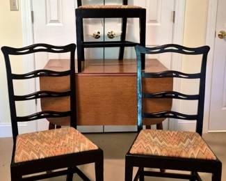 3737 - Drop Leaf Table w/ 3 Ribbon Back Chairs (Description): Drop leaf table with three ribbon back  chairs. The table features a warm oak finish  with a drop leaf design, while the chairs  have black lacquered frames with distinctive  wavy ribbon-style back slats. Two chairs feature chevron-patterned upholstered seats  in muted earth tones, while the third has a  rush seat. Table measures 29.5" x 51" x 36".