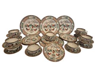 2728 - 32 Pc Oriental Rooster Plates Cups & Saucers (Description): A 32-piece set of Oriental porcelain  dinnerware featuring a traditional rooster  pattern. The collection includes plates,  cups, and saucers decorated with colorful  hand-painted roosters amid floral and garden motifs. Each piece is bordered with ornate  geometric and floral bands in vibrant hues of  green, orange, and blue. The largest plate  measures 10 inches in diameter.