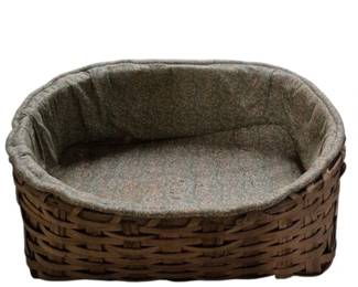 4129 - Large Vtg Woven Wicker Basket w/ Fabric Liner (Description): Large vintage woven wicker basket featuring a  dark brown finish and oval shape. The basket  is fitted with a padded fabric liner in a  muted floral pattern that covers both the  sides and bottom, creating a comfortable cushioned interior. Measures 9" x29" x 21".