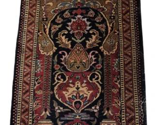 3973 - Small Persian Style Prayer Rug 24"x37" (Description): Small Persian style prayer rug featuring a  traditional mihrab design with floral and  foliate motifs. The rug displays a rich color  palette of deep navy, burgundy red, olive  green, and cream tones. The central field contains an ornate medallion and vase design  surrounded by multiple decorative borders  with geometric zigzag patterns. Hand-knotted  construction with natural fringe at both  ends.