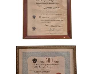 3959 - Two 1955 Ford Motor Company Awards Framed (Description): Two framed 1955 Ford Motor Company awards.  The first is a Championship Scoring Drive  Award for Sales Management Performance during  November-December 1955, presented to L.  Goode Toone, housed in a wooden frame with visible wear. The second is a Ford500 Club  certificate recognizing outstanding sales  ability, featuring a decorative ribbon and  seal, presented in a gilt frame. Both  certificates bear period signatures from Ford