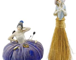 176 - Vintage Porcelain Lady Pin Cushion & Brush (Description): Two decorative porcelain beauty figures. One  features a half-doll figure mounted atop a  velvet pincushion, while the other is a  half-doll figure mounted as a whisk broom  handle.