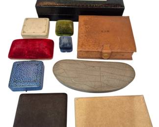 2708 - Group of Vintage Jewelry Boxes (Description): A collection of vintage jewelry boxes in  various styles and materials. The group  includes leather cases in brown and tan  tones, velvet-covered presentation boxes in  red and blue, small ring boxes, a cream-colored celluloid box with decorative  ribbed design, a black leather storage box,  and an oval shagreen-style case. Several  boxes feature snap closures, and one leather  case is monogrammed. An assorted lot suitable