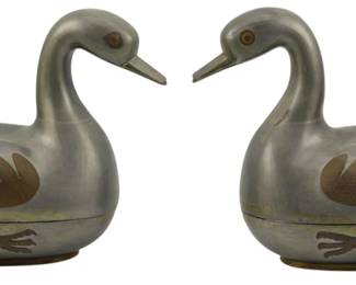 705 - Pr. Chinese Pewter Duck Boxes 7"x7"x4" (Description): A pair of Chinese pewter duck boxes featuring  decorative brass inlay with wing and foot  details. The lidded boxes are crafted in the  form of ducks with hinged bodies that open  for storage. Each measures 7 inches by 7 inches by 4 inches.