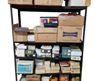 4142 - Shelf w/ Candles & Decor (Description): A shelf containing an assortment of candles  and decorative items. The collection includes  various boxed and unboxed pieces suitable  for home decor.