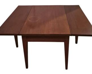 3759 - Drop Leaf Side Coffee Table (Description): Drop leaf side coffee table in a warm  mahogany-toned wood finish. Features clean  lines with tapered legs in a simple, classic  design. The table has two drop leaves that  extend to create a larger surface when open. Measures 18" x 36" x 30" when open