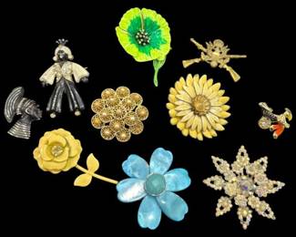 2813 - Group of Vtg Costume Brooches & Pins (Description): Group of vintage costume jewelry brooches and  pins featuring a variety of styles. The  collection includes floral designs such as a  yellow enamel rose, a blue flower with  faceted center stone, a gold-tone filigree flower with faux pearl accents, a green  enamel poppy, and a cream-colored sunflower.  Also included are figural pins featuring an  angel or fairy figure, a snowflake with  aurora borealis rhinestones, and whimsical