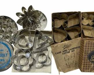 669 - Vintage Cookie Molds & Cutters (Description): Vintage cookie molds. This collection  includes various metal cookie and cake  cutters in assorted shapes, some in original  packaging. The lot features card suit shapes,  flower designs, and miniature aspic or jelly cutters among the assortment.