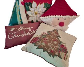 4079 - Group Lot of 5 Christmas Pillows (Description): Group lot of five decorative Christmas  pillows featuring assorted holiday designs.  The collection includes a Santa Claus face  pillow with a red quilted hat and pom-pom  trim, a poinsettia pillow with gold accents on red fabric, a Christmas tree pillow with  gold garland design on white background, an  embroidered Christmas tree pillow with  presents on cream fabric, and a burgundy  pillow with "Merry Christmas" script