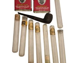 2739 - Vtg Smoking & Tobacciana Lot Prince Albert (Description): A vintage smoking and tobacciana collection  featuring two Prince Albert Crimp Cut tobacco  tins, a carved wooden pipe, and an  assortment of glass cigar tubes with cork  stoppers, some bearing Gold Label branding. A nostalgic grouping of mid-century smoking  accessories and memorabilia.