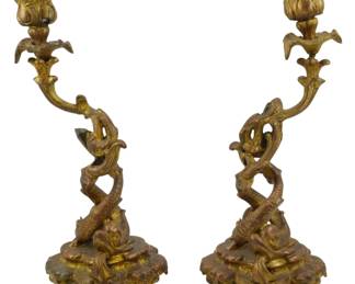 1876 - Pr Rococo Revival Brass Dragon Candlesticks (Description): A pair of Rococo Revival brass dragon  candlesticks featuring intertwined dragon  forms rising from ornate bases to support  decorative candle cups. Marked J.B. Each  measures 10.5 inches in height.