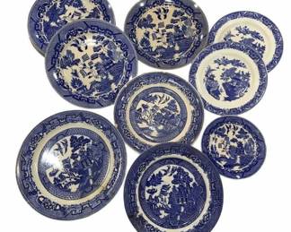 971 - Collection of Blue Willow Transfer Plates (Description): The group includes nine plates of varying  sizes, each featuring the traditional  chinoiserie design with pagodas, bridges,  willow trees, and birds. The plates display  slight variations in their border designs and pattern interpretations, suggesting they may  be from different makers or periods.