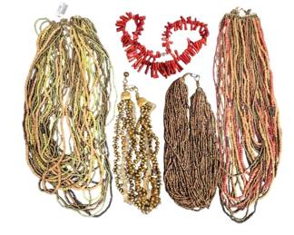 1497 - Assorted Beaded Multi-Strand Necklaces (Description): A collection of multi-strand beaded necklaces  featuring various styles and colors. The lot  includes several seed bead necklaces in  earth tones of green, yellow, peach, and  brown, a golden beaded necklace with decorative end caps, brown wooden or seed  bead strands, coral branch-style beaded  necklaces in red, and a multi-strand necklace  in warm pink and brown tones. Each necklace  features multiple strands gathered with