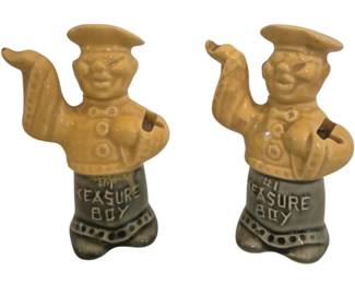 2779 - Pair Ceramic Measure Boy Figurines (Description): Figurines in the form of smiling boys with  outstretched arms. Each piece features a  yellow glazed upper body with textured  detailing and a gray glazed lower portion  marked "Measure Boy." The charming folk-style figures function as resting stands for  measuring spoons.