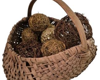 3747 - Large Split Weave Basket w/ Decorative Orbs (Description): Large split weave basket with bent wood  handle, measuring 21" x 22". The basket  features a traditional woven construction in  natural tan tones and comes filled with an  assortment of decorative spheres including twig balls, grapevine orbs, and textured  accent balls in various sizes and earthy  brown and gold tones.