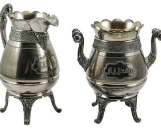 193 - Ca. 1890 Quadruple Plate Creamer & Sugar (Description): A circa 1890 quadruple plate creamer and  sugar set. Both pieces feature decorative  handles and rest on ornate footed bases. The  set displays monogrammed cartouches on each  piece.