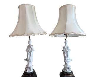 1359 - Pr Oriental Blanc de Chine Guanyin Lamps 31" (Description): Pair of oriental table lamps featuring blanc  de chine porcelain Guanyin figures. Each lamp  depicts the Buddhist goddess of mercy in  flowing robes standing atop a lotus base. The  white glazed porcelain figures are mounted on carved wooden bases and fitted with cream  silk bell shades with scalloped edges and  decorative trim. Measures 31 inches tall. Used as is electric/electronic/mechanical  item. No guarantee all components, untested.