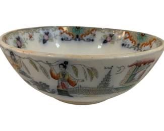 320 - Chinese Famille Rose Figural Scene Bowl (Description): Chinese porcelain bowl decorated in the  Famille Rose palette featuring hand-painted  figural scenes depicting a woman in  traditional dress on a terrace with pagodas,  willow trees, and architectural elements. The interior rim is adorned with colorful floral  motifs, scrollwork, and geometric patterns.  The bowl shows typical characteristics of  Chinese export porcelain with polychrome  enamels on a white ground. Measures 4.5" x