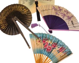 1446 - Collection of Decorative Asian Paper Fans (Description): Featuring various styles and designs. The  grouping includes a round brown fan with  gilded floral motif on rustic metal handles,  a colorful painted paper fan depicting a  scenic mountain landscape, a purple fabric fan with tassel accent, a cream-colored fan  with pink orchid design marked 'The Royal  Orchid Service,' and a large hand-painted fan  with pink floral design on a blue gradient  background with bamboo ribs.