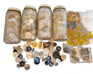 1451 - Vtg Button Collection in Glass Jars (Description): Vintage button collection featuring an  assortment of buttons in various sizes,  colors, and materials. The lot includes four  glass jars filled with predominantly cream,  ivory, and natural-toned buttons, along with a loose selection of buttons in shades of  white, cream, brown, black, and navy. Also  included is a small container of metallic  beads and a collection of amber and smoky  faceted glass or crystal buttons. The buttons