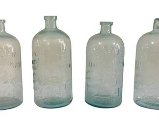 415 - 4 Buffalo Spring Water Bottles, 1 Cracked (Description): Four vintage Buffalo Spring Water bottles in  aqua-tinted glass with embossed lettering and  trademark designs. One bottle is cracked.  Each measures 10 inches tall.