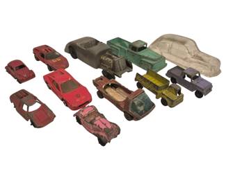 2730 - 11 Vtg Diecast Toy Cars & Trucks Collection (Description): A collection of 11 vintage diecast toy cars  and trucks in various styles and colors. The  assortment includes sports cars, trucks, a  jeep, and classic automobiles in red, green,  gray, yellow, pink, and purple finishes. One clear plastic car body is also included. The  vehicles show varying degrees of age-related  wear consistent with vintage playthings.